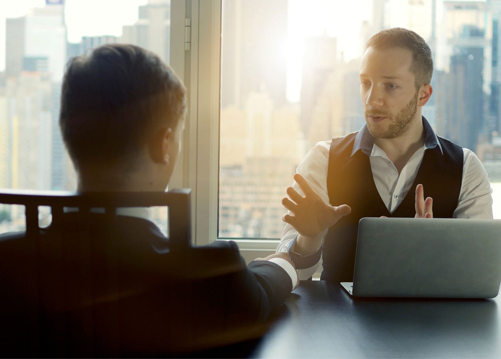 An interviewer listening closely across a table